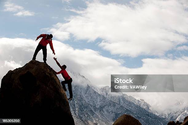 Foto de Homem No Topo Da Montanha Ajudar Alguém e mais fotos de stock de Assistência - Assistência, Dar a Mão, Help - Palavra Única