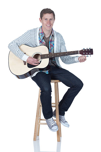 istock Man sitting on stool and playing a guitar 185306009