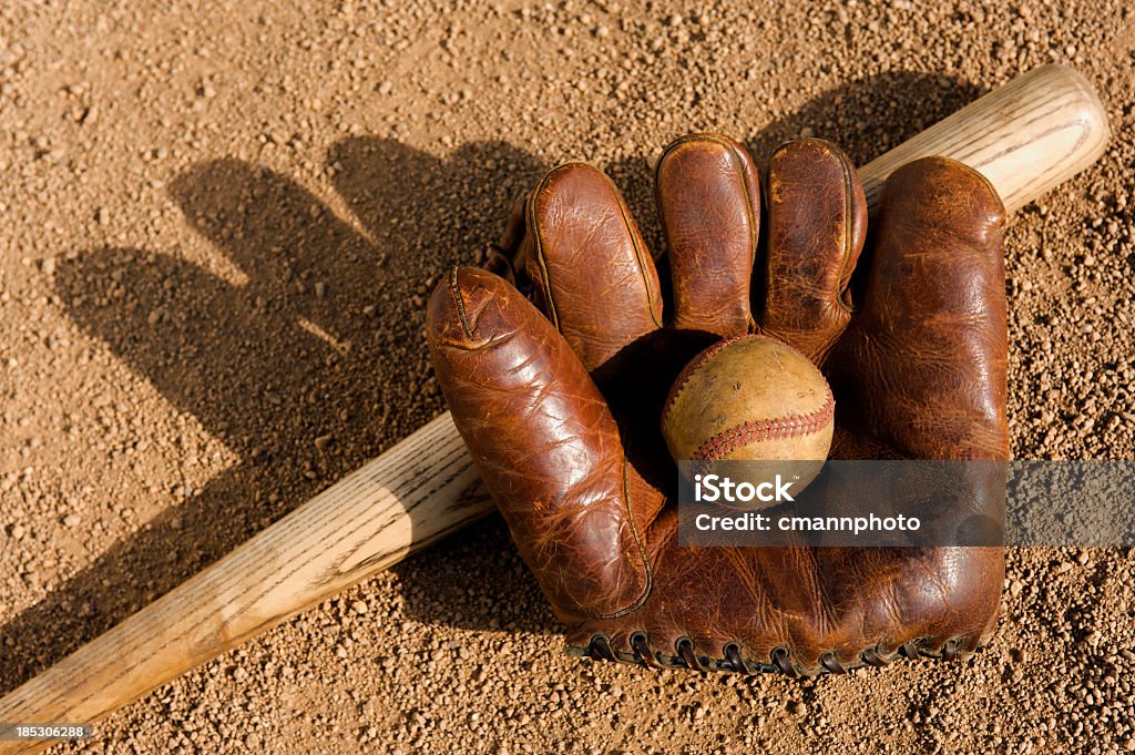 Baseball - Old Timers A vintage baseball glove,ball and bat sitting in the dirt Old Stock Photo