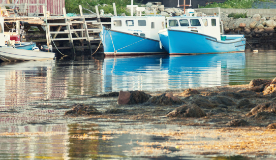 Two Cape Islander fishing boats tied at a small pier.