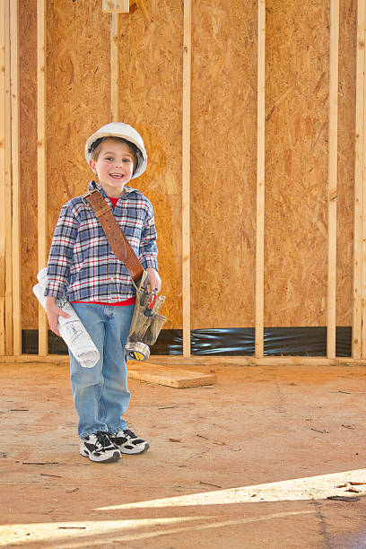 istock Boy With Tool Belt & Hardhat Standing In New Home Construction 185307651