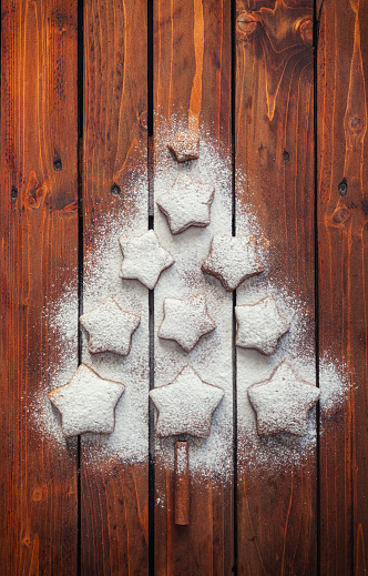 Christmas tree made with powdered sugar and star shaped gingerbread cookies