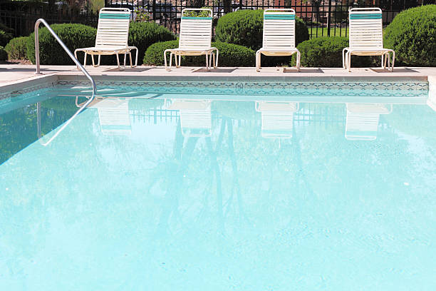 istock four sunbeds and handrail  around  turquoise swimming pool 185307759