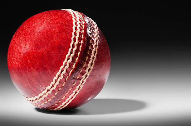 istock Red leather cricket ball on black background with copy space 185308414