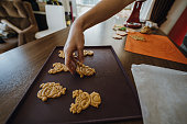 Woman's hands spreading ginger cookies on a baking tray.