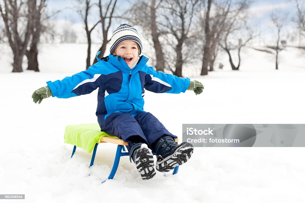 Petit garçon sur la luge dans la neige - Photo de 4-5 ans libre de droits