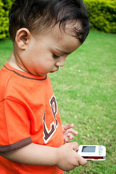 istock One Little Indian Boy with Mobile Phone 185309215