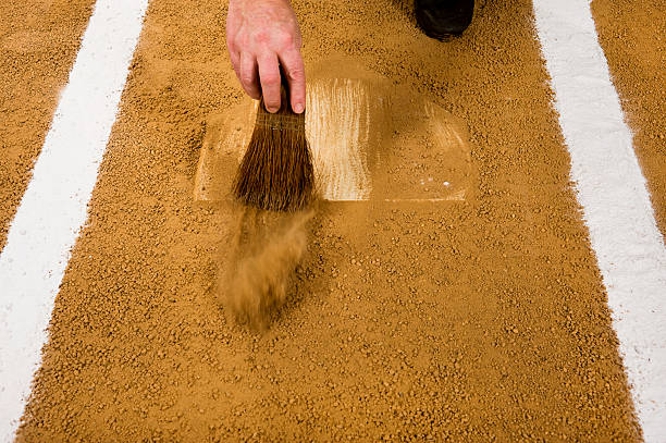Baseball umpire cleaning home plate. Play Ball