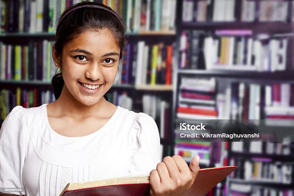 Indian Rapariga adolescente a estudar em uma biblioteca com Estante de Livro - Royalty-free Povo Indiano Foto de stock