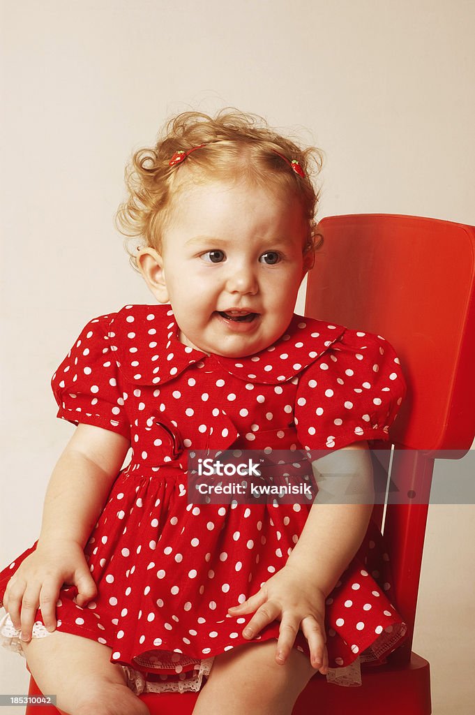 little baby sitting on red chair 12-23 Months Stock Photo