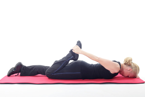 Woman doing a stretching exercise for her front of thighs quadriceps