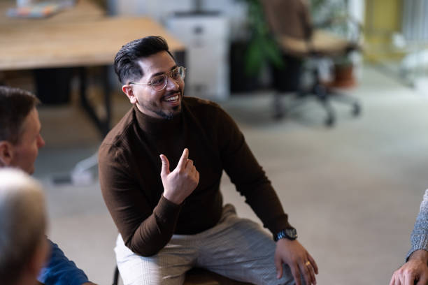 istock Young man talking with team during a meeting in an office 1853103917