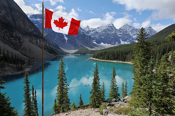 Canada The Canadian National flag set against the Rocky Mountains of Banff National ParkCanada moraine lake stock pictures, royalty-free photos & images