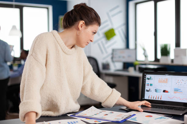 istock Company manager reading, analysing statistics on laptop 1853111122