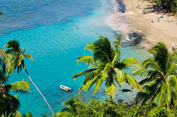 People on the beach and in the water, snorkeling and swimming, at Ke`e Beach on Kauai, Hawaii.