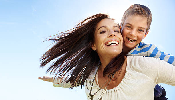 istock Happy son on smiling mother's back on a sunny day 185311696