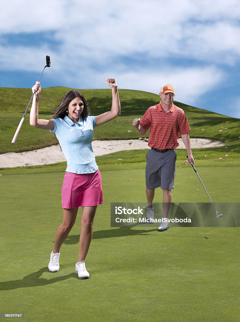 Golfer Celebration A cute couple celebrating a made putt on the golf course. Golf Stock Photo