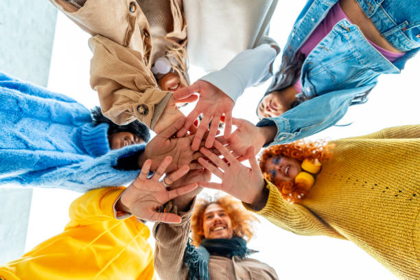 istock Group of diverse young people join hands in circle 1853124098