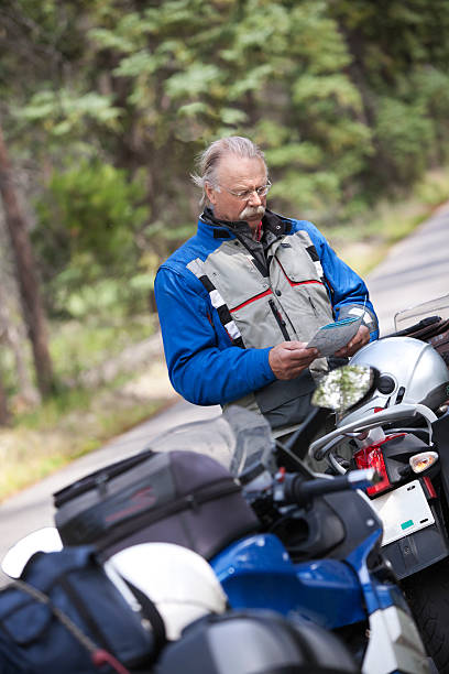 istock Motorcyclist reading map with motorcycle on road. 185312683
