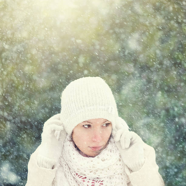 istock young woman adjusting her cap on a snowy day 185312760