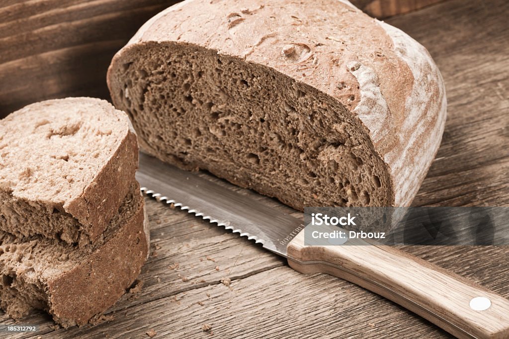 Bread slices Brown bread slices (can be black wheat, or oat), with bread knife in  wooden bread box; Adobe rgb color space. Rostfrei text: German for stainless. Cross Section Stock Photo