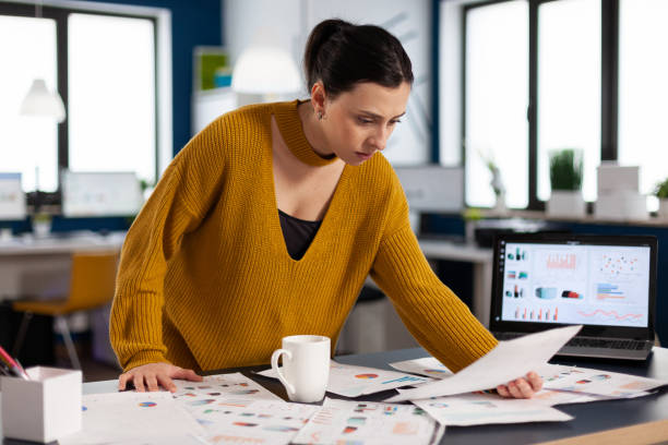 istock Project leader preparing presenstation for investors using printed charts 1853128317