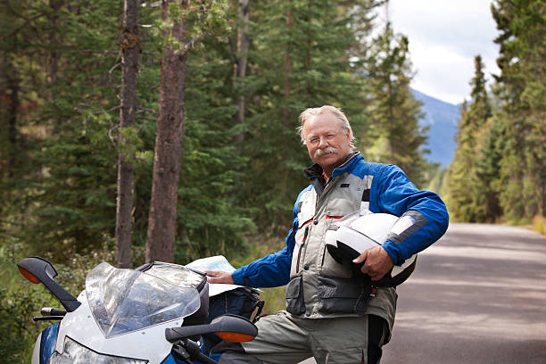 istock Motorcyclist reading map with motorcycle on road. 185313030