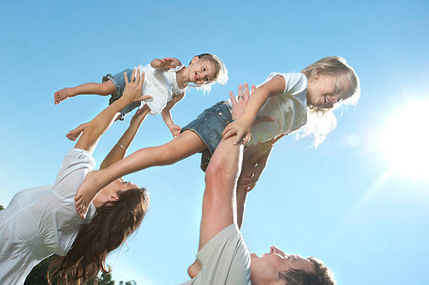 istock Parents joyfully throwing their children in the air. 185313400