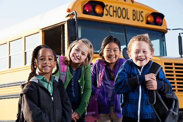 bambini in piedi fuori scuola bus - sc0536 foto e immagini stock