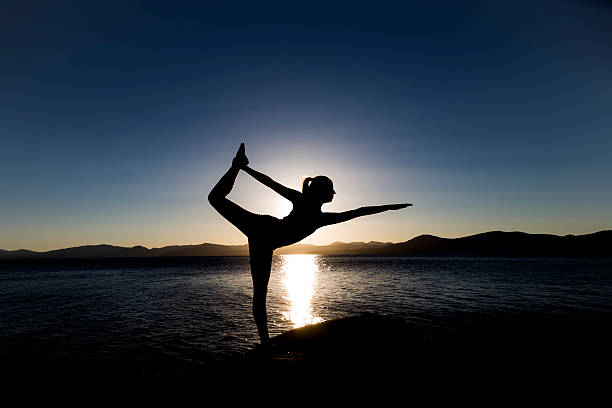 Yoga sillhouette at sunset in Lake Tahoe stock photo