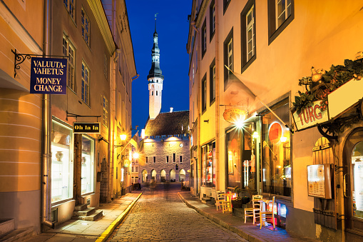 Stores and restaurant in Old Town Tallinn, Estonia at night, with the Town Hall building. UNESCO World Heritage Site.
