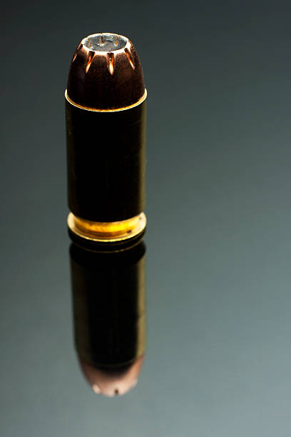 istock Single .45 Caliber Hollowpoint Bullet on Reflective Grey Background 185317070
