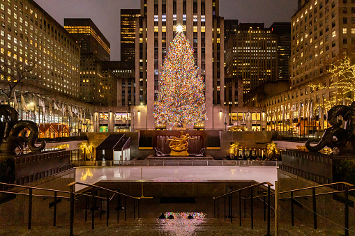 New York, NY, USA - December 11, 2023: Rockefeller Center during Christmas time with the tree lit up and no one on the ice skating rink.