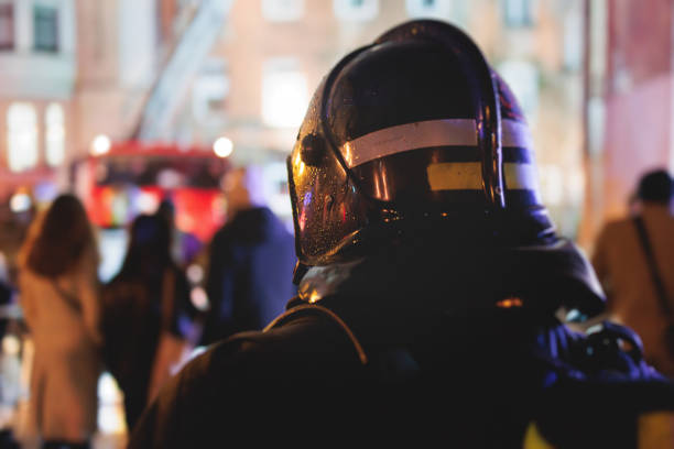 istock Group of fire men in protective uniform during fire fighting operation in the night city streets, firefighters brigade with the fire engine truck vehicle, emergency and rescue service 1853172340