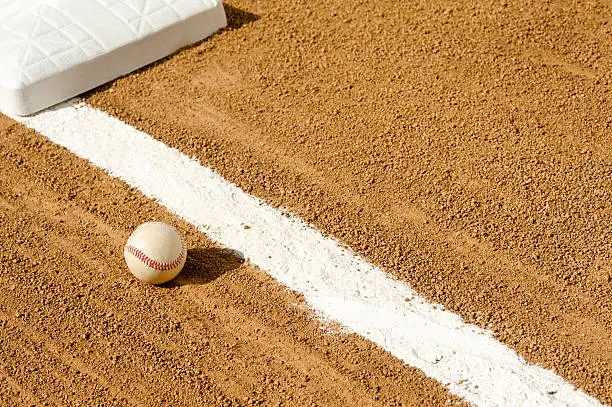 A foul ball up the third base line, with an imprint in the chalk line where the ball rolled over the foul line.