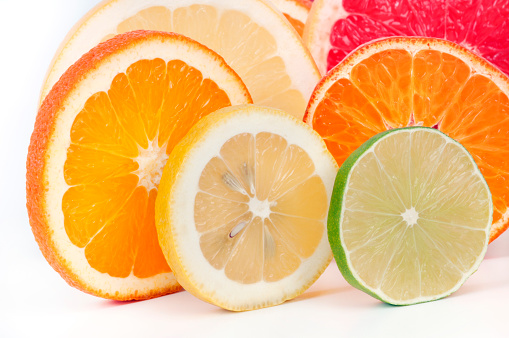 Slices of fruits on white background. One by one standing.
