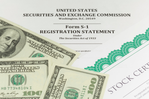 The top portion of the title page of an SEC Form S-1 (IPO registration statement), along with a portion of a generic stock certificate and three $100 bills.