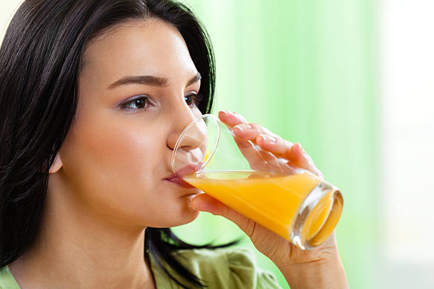 istock Young girl drinking fresh orange juice 185317851