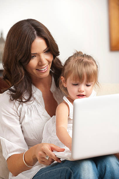 istock Little girl and her mother using a laptop 185318407