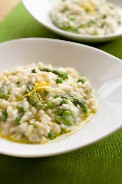 Two round plates served with spring risotto stock photo
