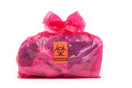 A red bio-hazard bag containing medical waste with a bio-hazard label. Background is 255 white.