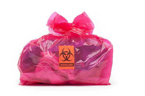 Bio-hazard bag/small A red bio-hazard bag containing medical waste with a bio-hazard label. Background is 255 white. toxic waste stock pictures, royalty-free photos & images