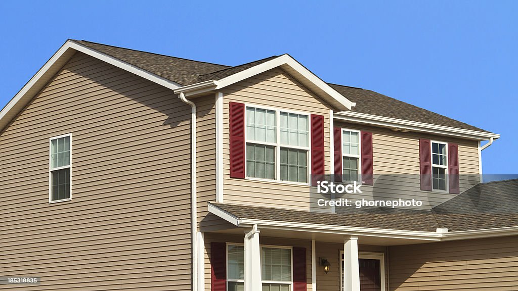 New home construction,showing siding,roof,and gutters "A photograph showing a new home with tan vinyl siding, shutters, a new roof and gutters" Siding - Building Feature Stock Photo