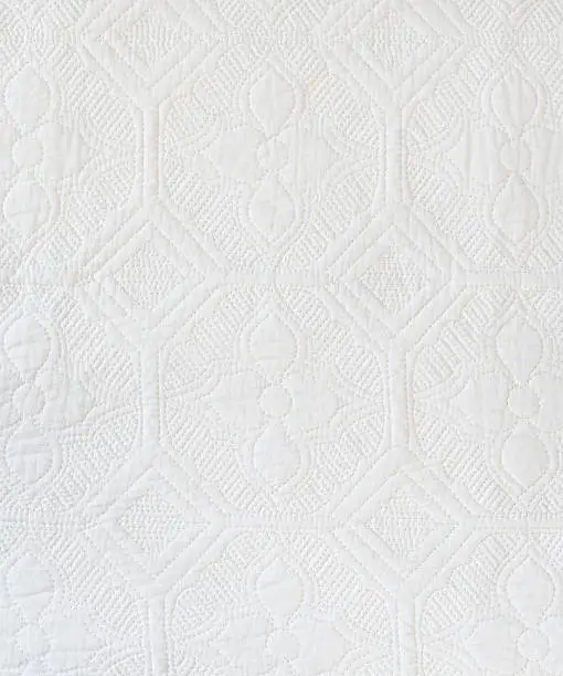 White quilt textile shot from directly above for use as a background or texture.  This image was created by merging three shots to yield greater detail and still show repetition of pattern.More White Backgrounds: