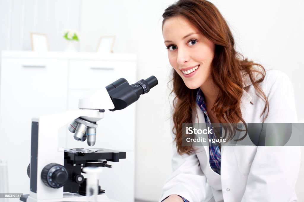 Femme scientifique regardant à travers un microscope - Photo de 20-24 ans libre de droits