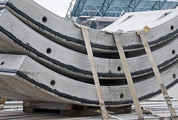 Three concrete tunnel-segment liners strapped to truck waiting for placement in light-rail tunnel being dug in Seattle WA