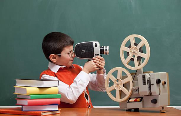 Little Boy Filming With Video Camera In Front Of Blackboard stock photo
