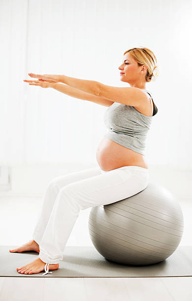 bella donna incinta facendo esercizi. - human pregnancy prenatal care relaxation exercise ball foto e immagini stock