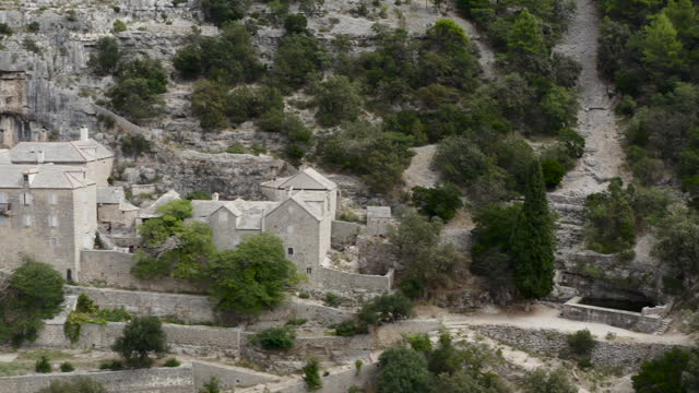Mountainside Monastery Of Pustinja Blaca In A Deserted Remote Area On Brac Island, Croatia. Aerial Sideways Shot