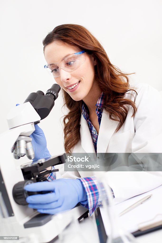 Femme scientifique à l'aide d'un microscope - Photo de 20-24 ans libre de droits